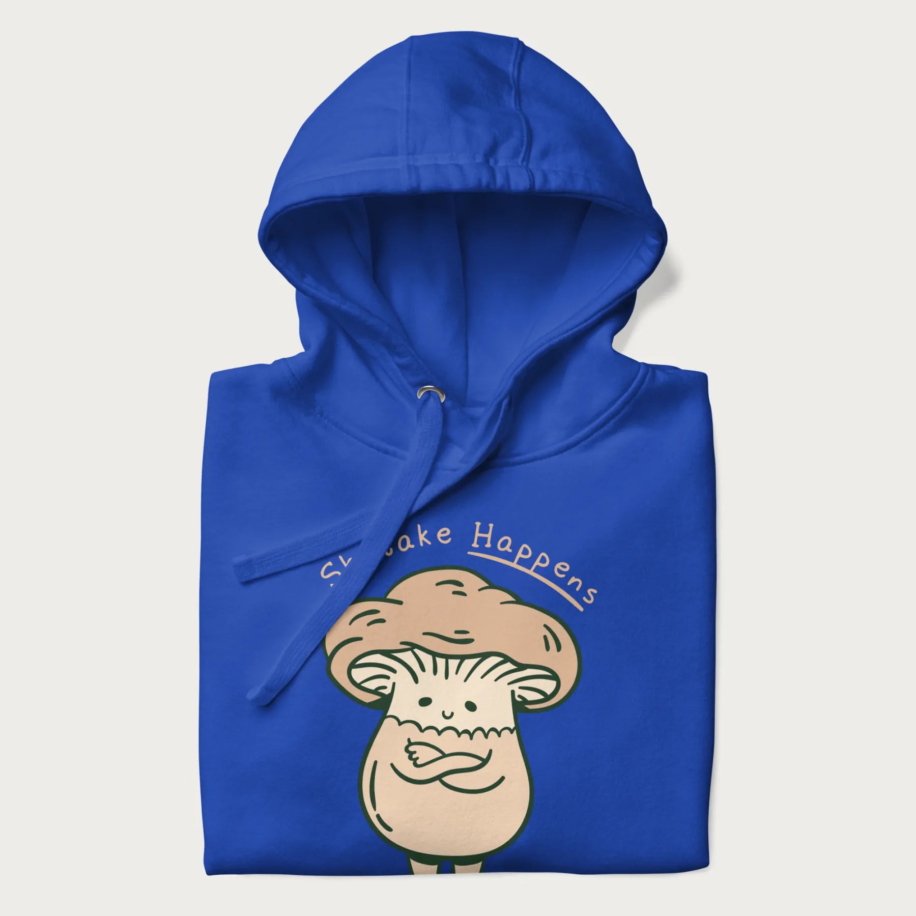 Folded royal blue hoodie with a graphic of an adorable mushroom character and the text 'Shiitake Happens'.