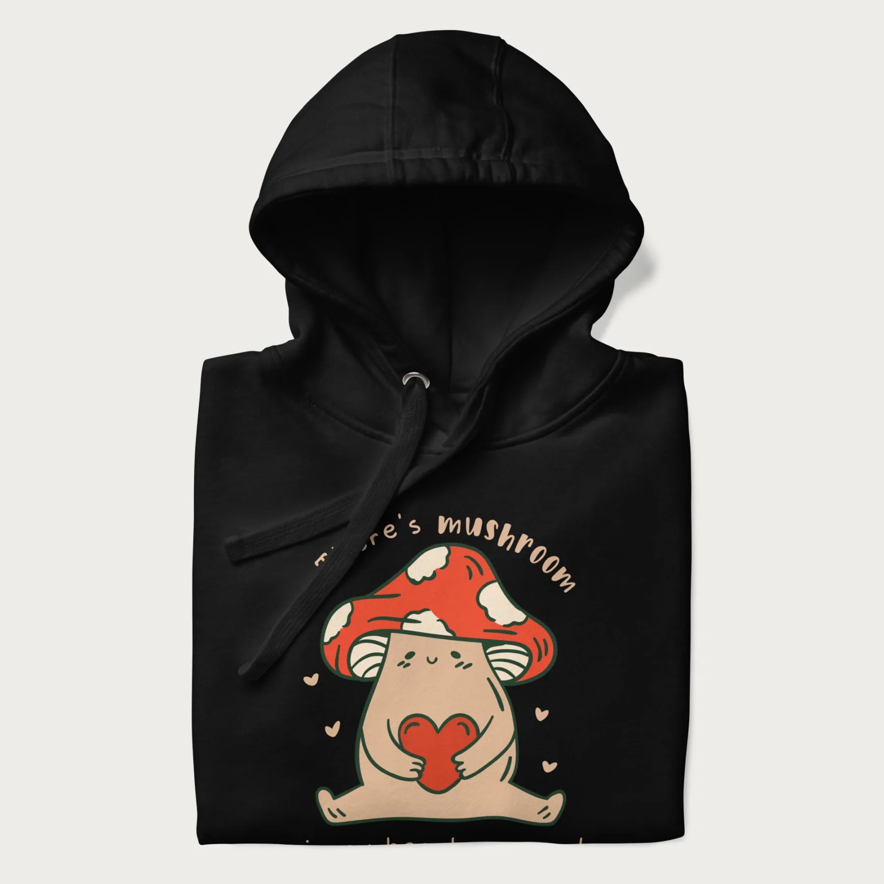 Folded black hoodie with a graphic of a mushroom character holding a heart and the text 'There's Mushroom in My Heart for You'.