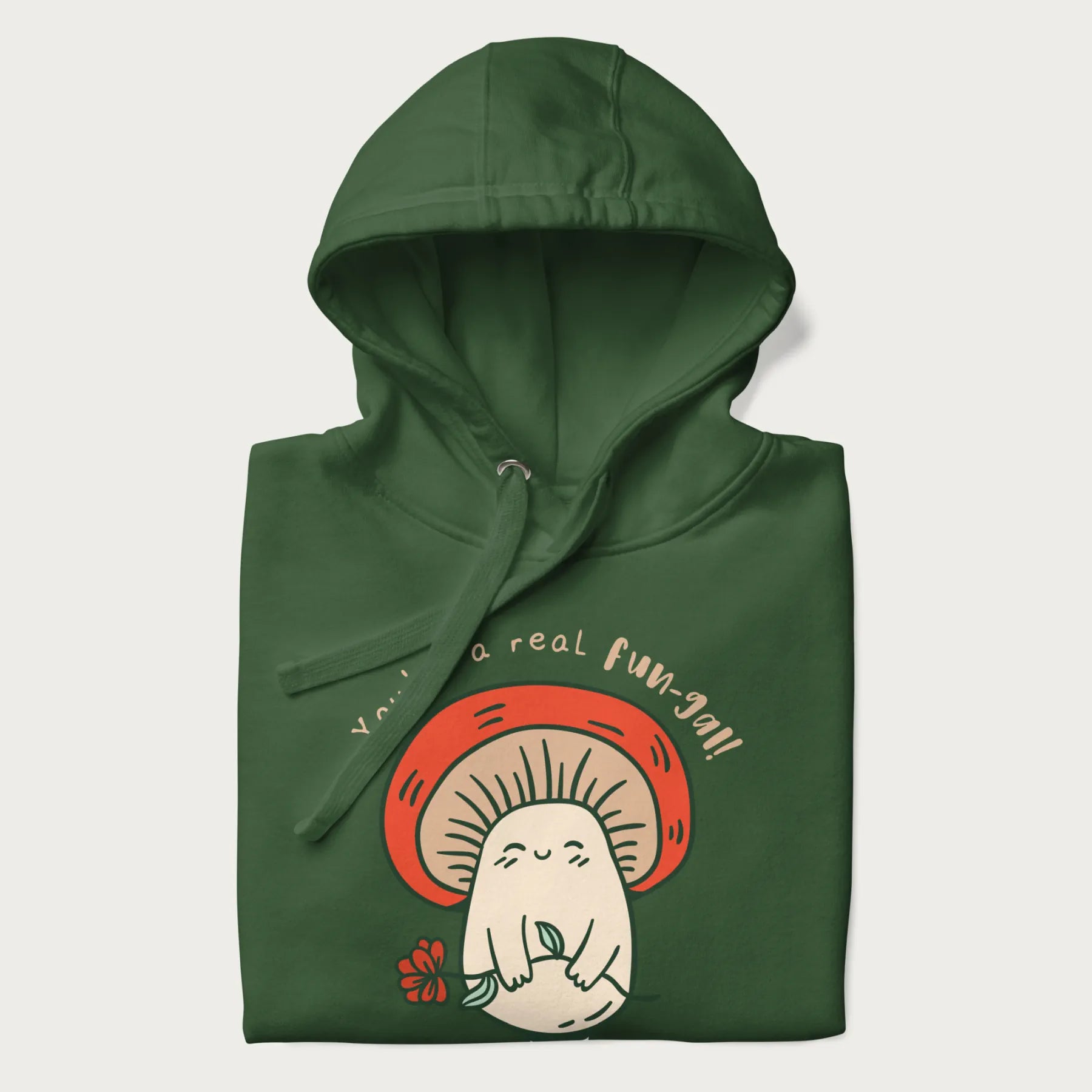 Folded forest green hoodie with a graphic of a cute mushroom character holding a flower and the text 'You're a real fun-gal!'.