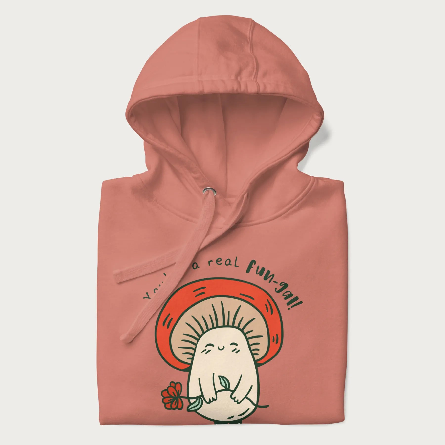 Folded light pink hoodie with a graphic of a cute mushroom character holding a flower and the text 'You're a real fun-gal!'.