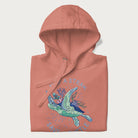 Folded light pink hoodie with a graphic of a sea turtle with coral on it's shell and the text 'Skip a Straw, Save a Turtle'.