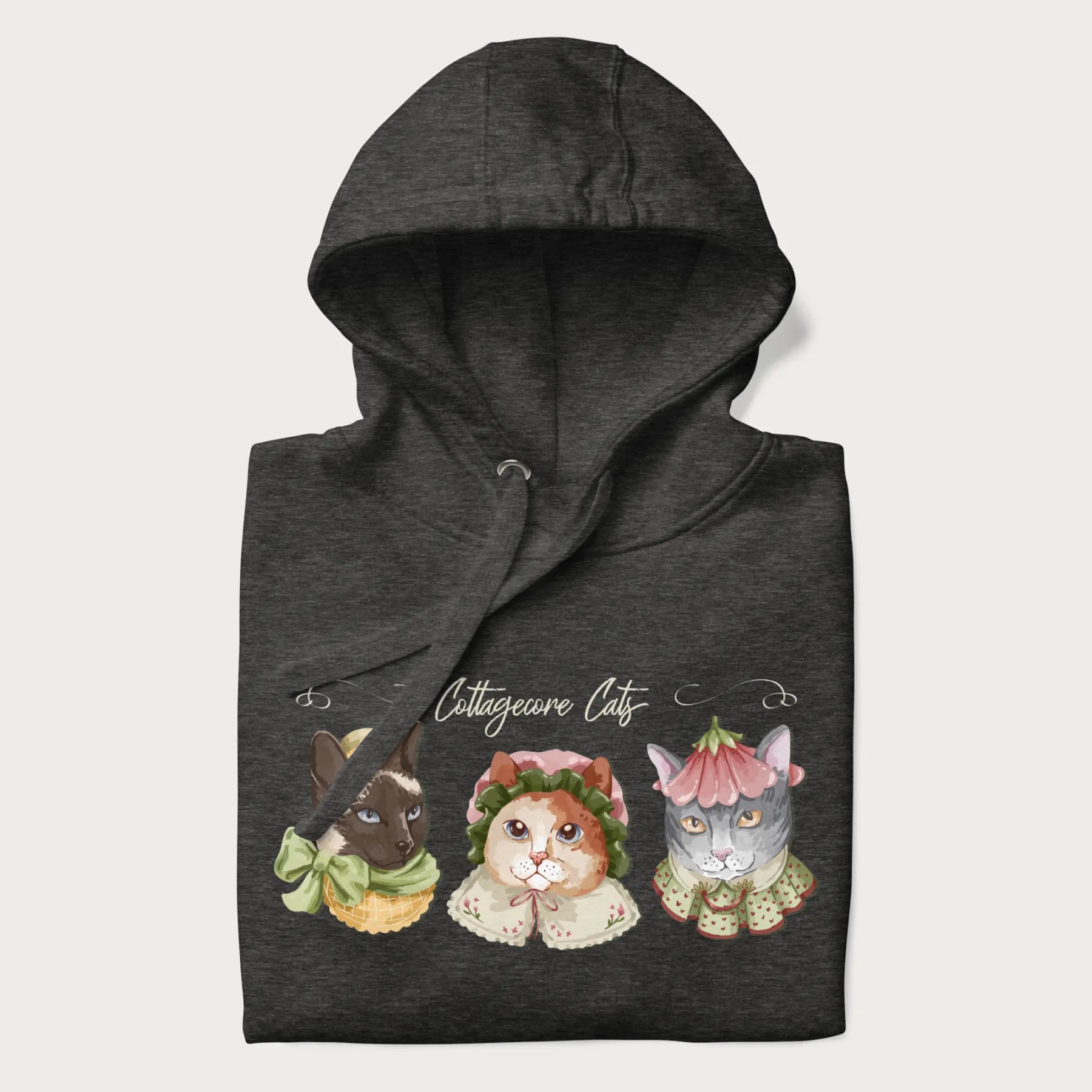 Folded dark grey hoodie with a graphic of three cats in vintage-inspired attire and the text 'Cottagecore Cats'.