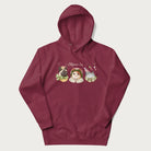 Maroon hoodie with a graphic of three cats in vintage-inspired attire and the text 'Cottagecore Cats'.