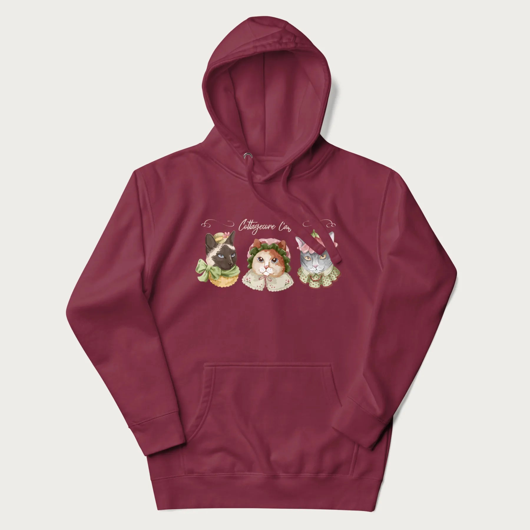 Maroon hoodie with a graphic of three cats in vintage-inspired attire and the text 'Cottagecore Cats'.