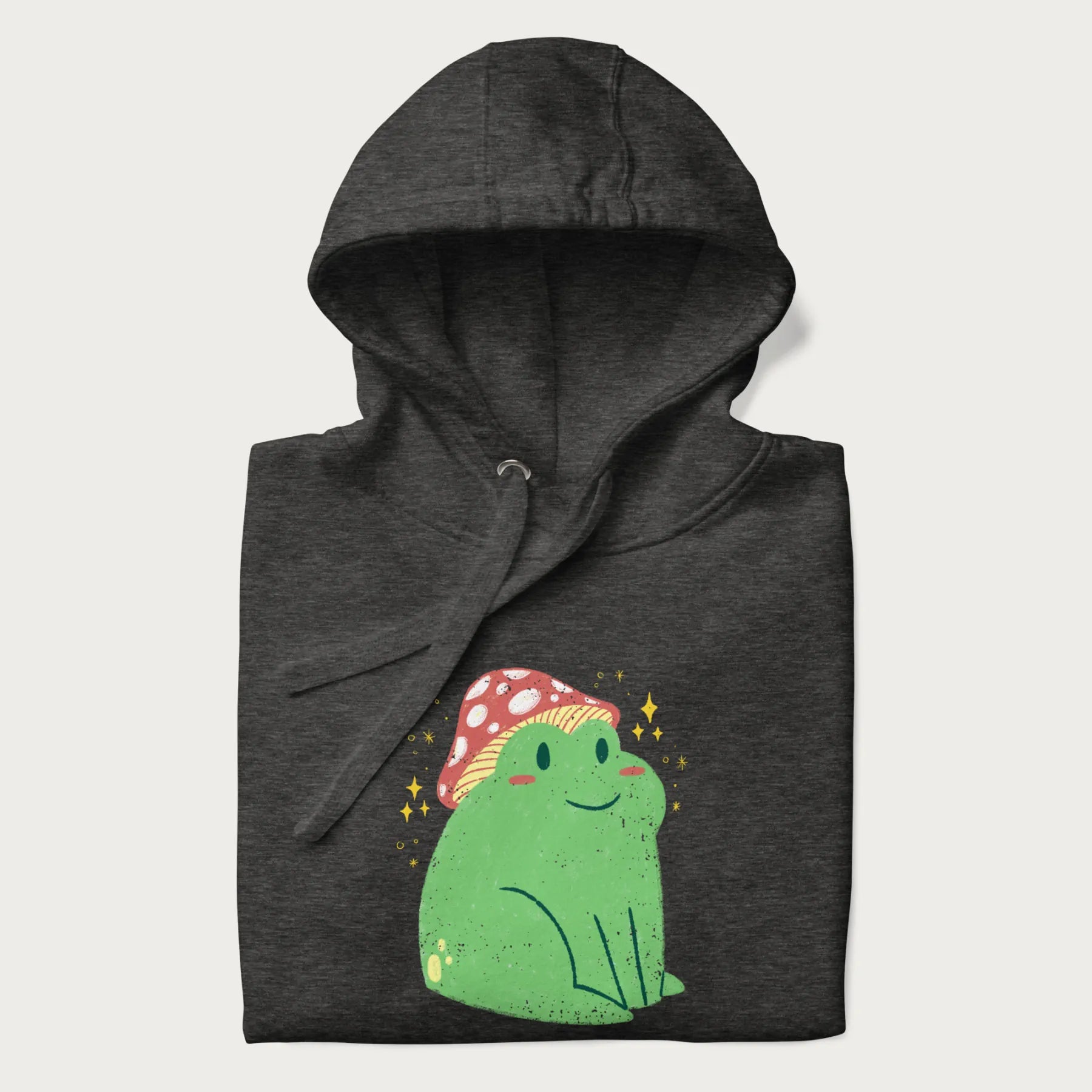 Folded dark grey hoodie with a graphic of a green frog wearing a mushroom cap surrounded by stars.