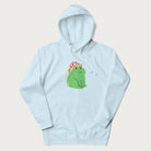 Light blue hoodie with a graphic of a green frog wearing a mushroom cap surrounded by stars.