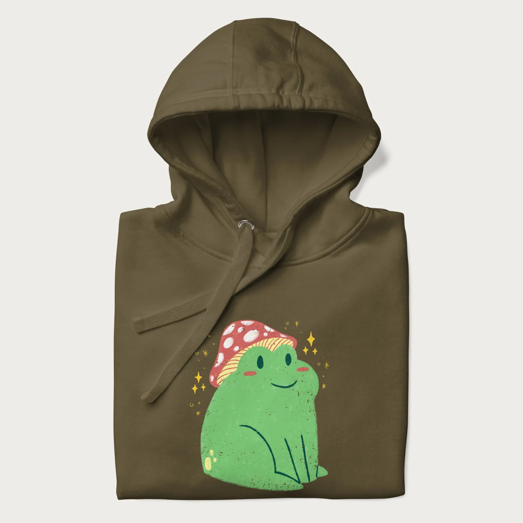 Folded military green hoodie with a graphic of a green frog wearing a mushroom cap surrounded by stars.