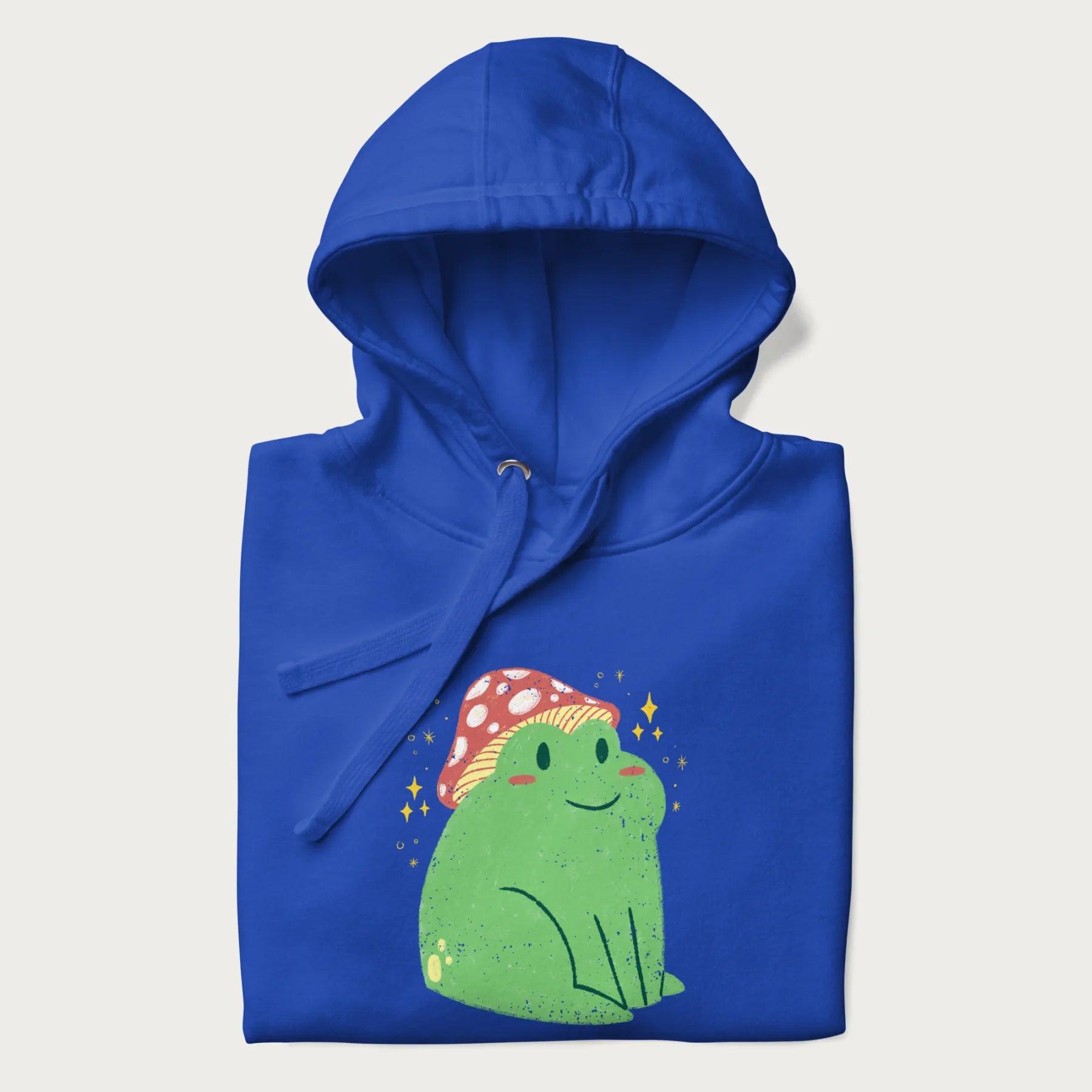 Folded royal blue hoodie with a graphic of a green frog wearing a mushroom cap surrounded by stars.