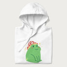 Folded white hoodie with a graphic of a green frog wearing a mushroom cap surrounded by stars.