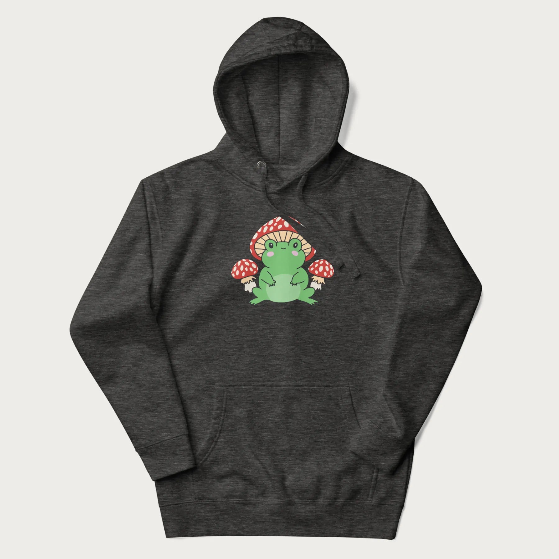 Folded white hoodie will illustration of a cute green frog with red and white mushrooms.