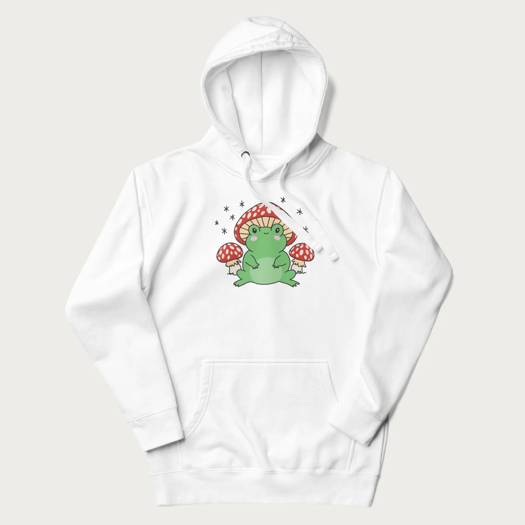 White hoodie will illustration of a cute green frog with red and white mushrooms.