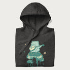 Folded dark grey hoodie with graphic of a frog playing a banjo on a mushroom with stars and a crescent moon.