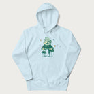 Light blue hoodie with graphic of a frog playing a banjo on a mushroom with stars and a crescent moon.