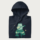 Folded navy blue hoodie with graphic of a frog playing a banjo on a mushroom with stars and a crescent moon.