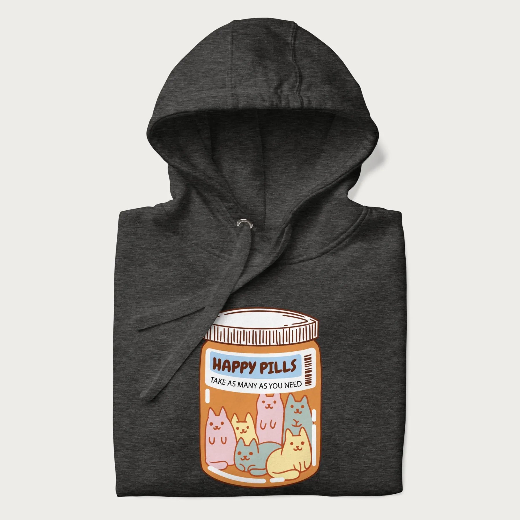 Cartoon cats in a pill bottle labeled 'Happy Pills' on a folded dark grey hoodie.
