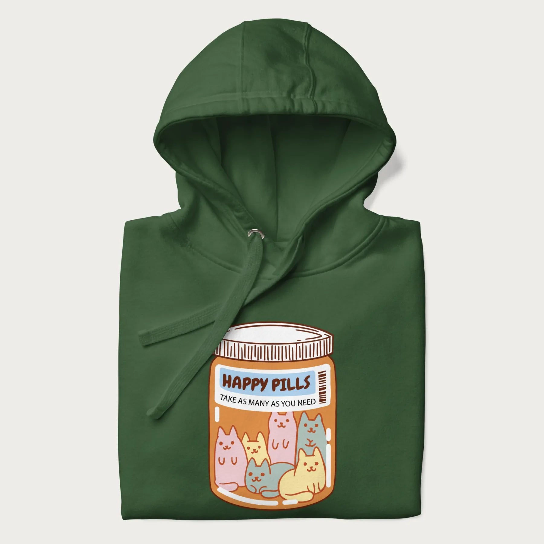 Cartoon cats in a pill bottle labeled 'Happy Pills' on a folded dark green hoodie.