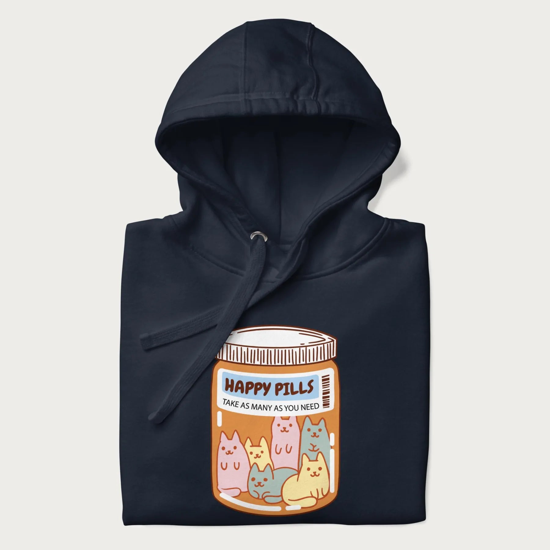 Cartoon cats in a pill bottle labeled 'Happy Pills' on a folded navy blue hoodie.