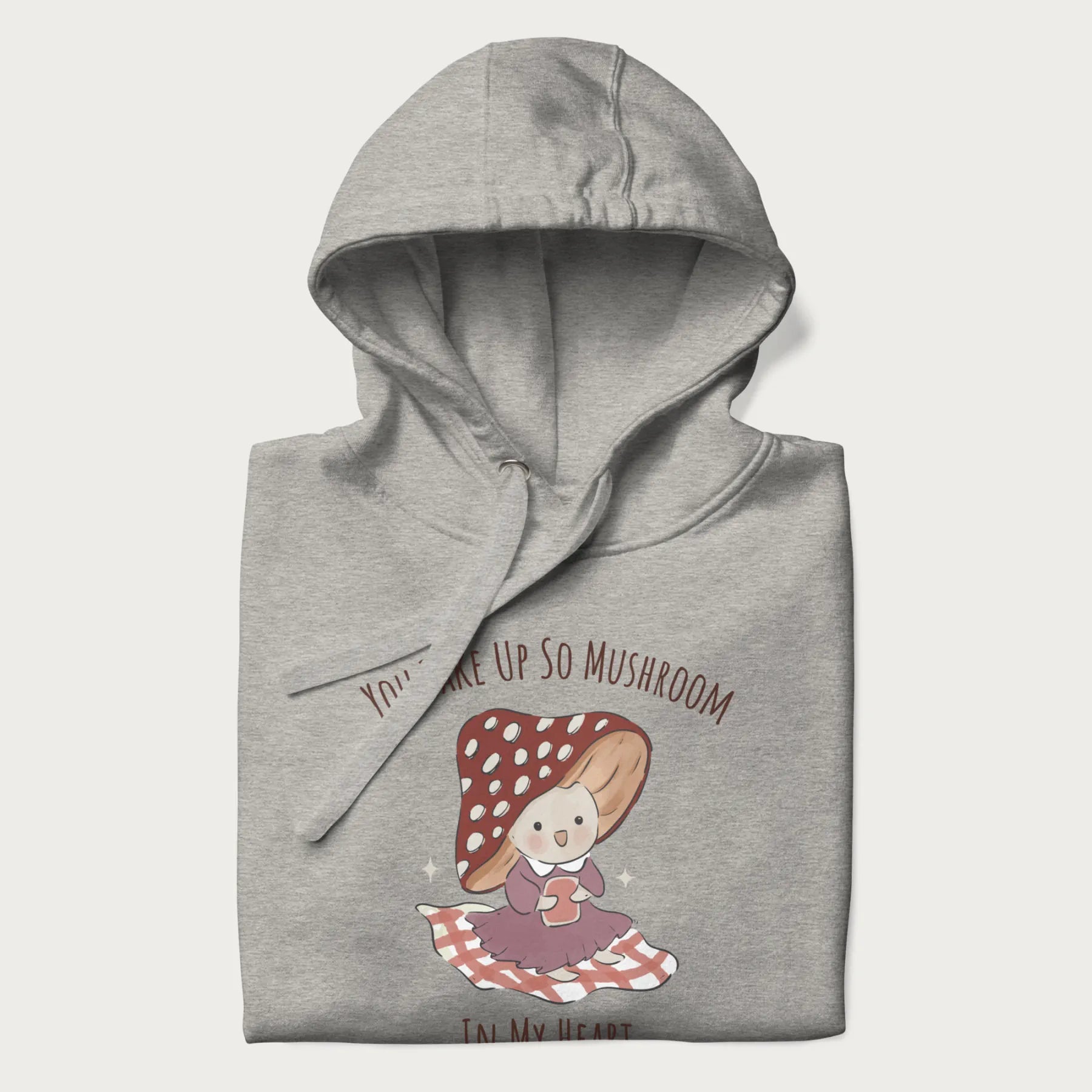 Folded light grey hoodie with a cute mushroom character and the text 'You Take Up So Mushroom in My Heart'.