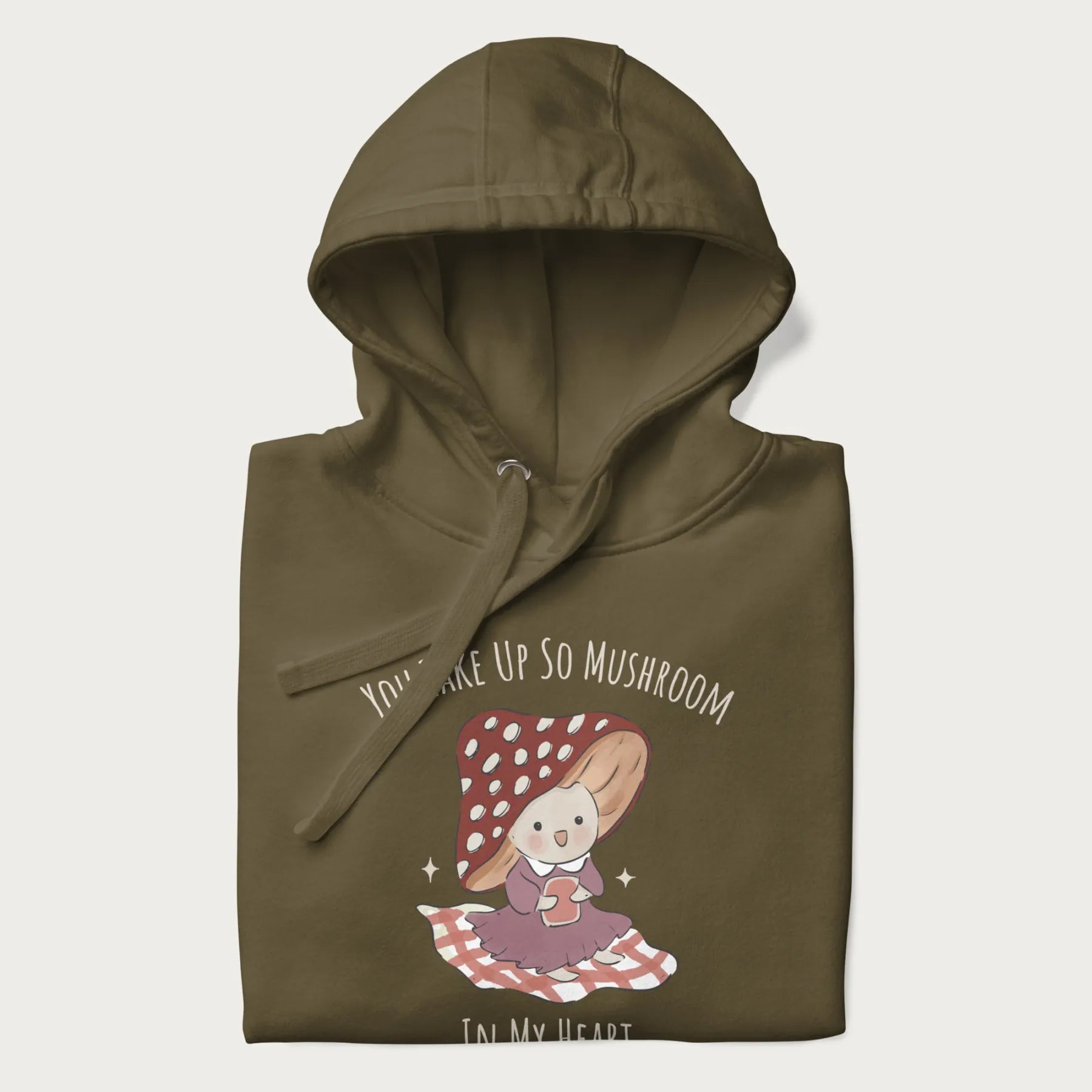 Folded military green hoodie with a cute mushroom character and the text 'You Take Up So Mushroom in My Heart'.