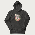 Dark grey hoodie with graphic of an adorable raccoon surrounded by mushrooms, foliage, and a crescent moon with stars in the background.