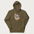 Military green hoodie with graphic of an adorable raccoon surrounded by mushrooms, foliage, and a crescent moon with stars in the background.