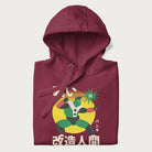 Folded maroon hoodie with Japanese text and retro graphic of a cyborg.