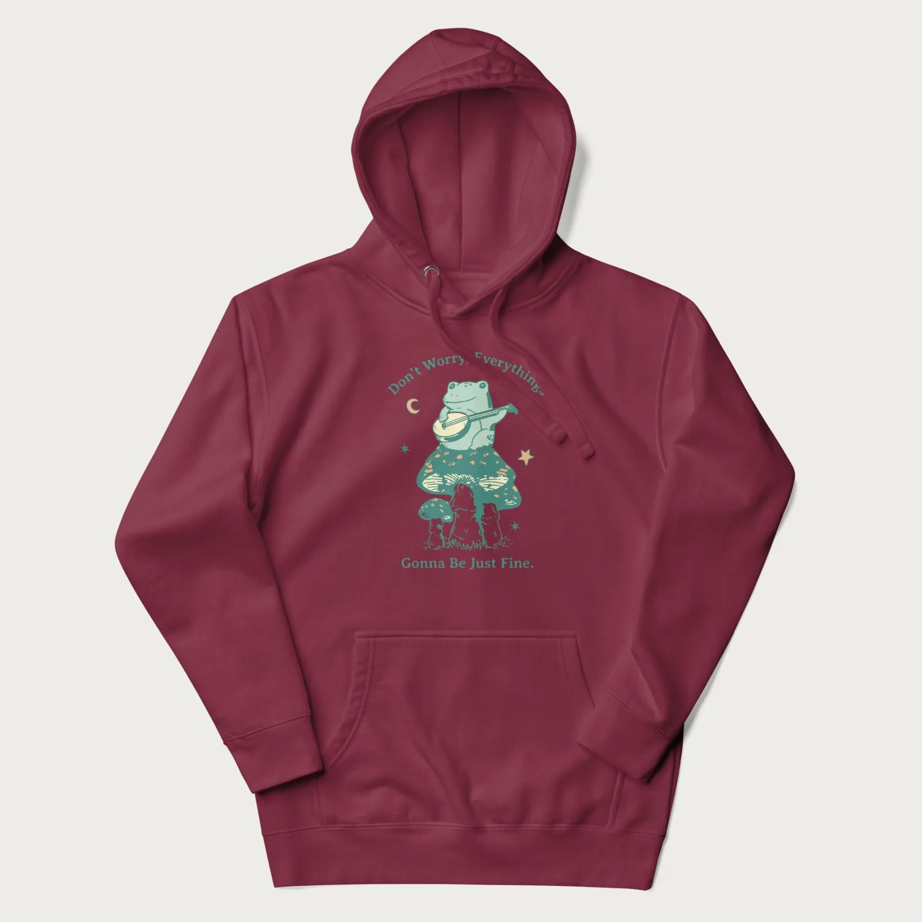 Maroon hoodie with a graphic of a frog playing a banjo on a mushroom under the moon and stars, with the text 'Don't Worry, Everything's Gonna Be Just Fine.'