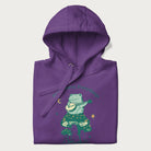 Folded purple hoodie with a graphic of a frog playing a banjo on a mushroom under the moon and stars, with the text 'Don't Worry, Everything's Gonna Be Just Fine.'