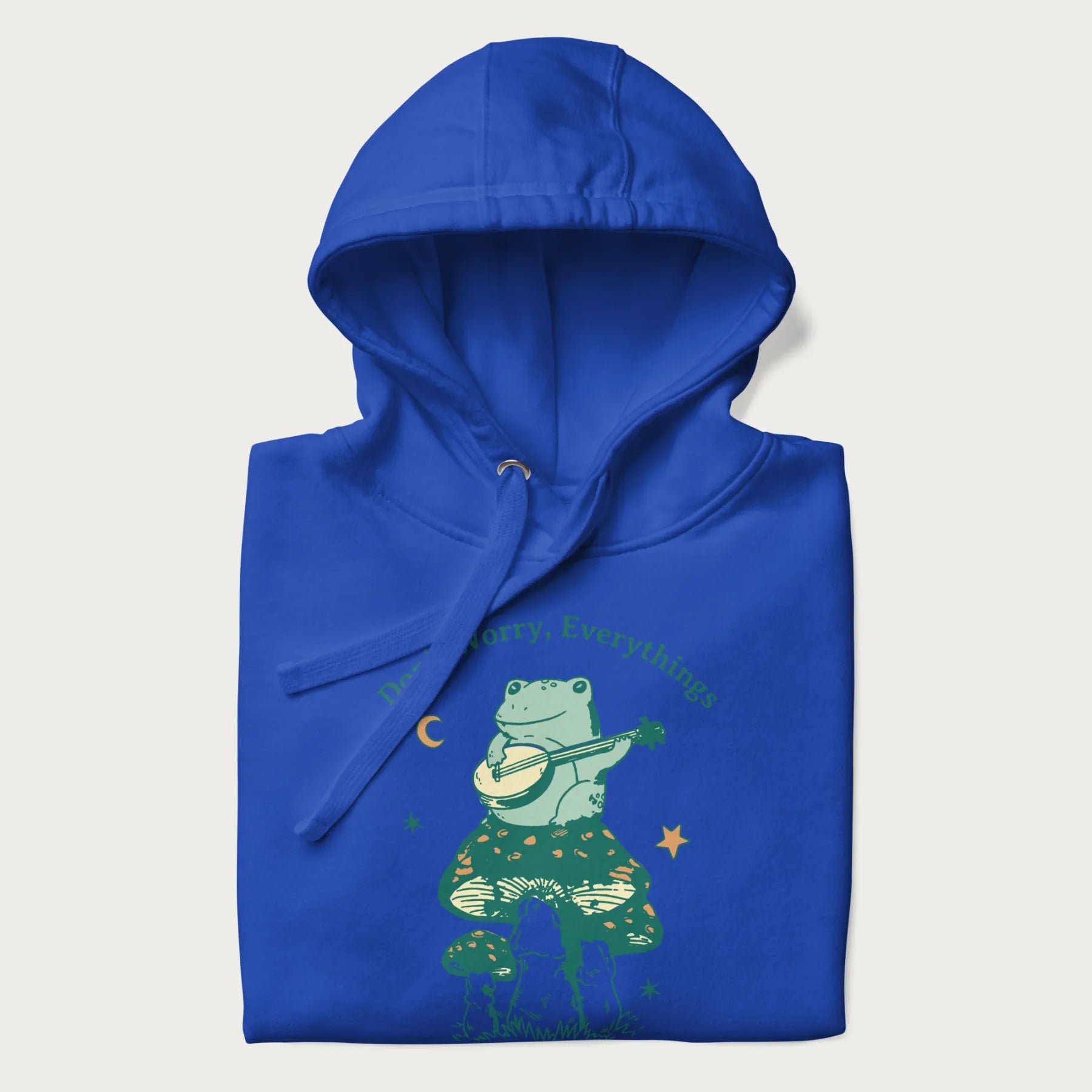 Folded royal blue hoodie with a graphic of a frog playing a banjo on a mushroom under the moon and stars, with the text 'Don't Worry, Everything's Gonna Be Just Fine.'