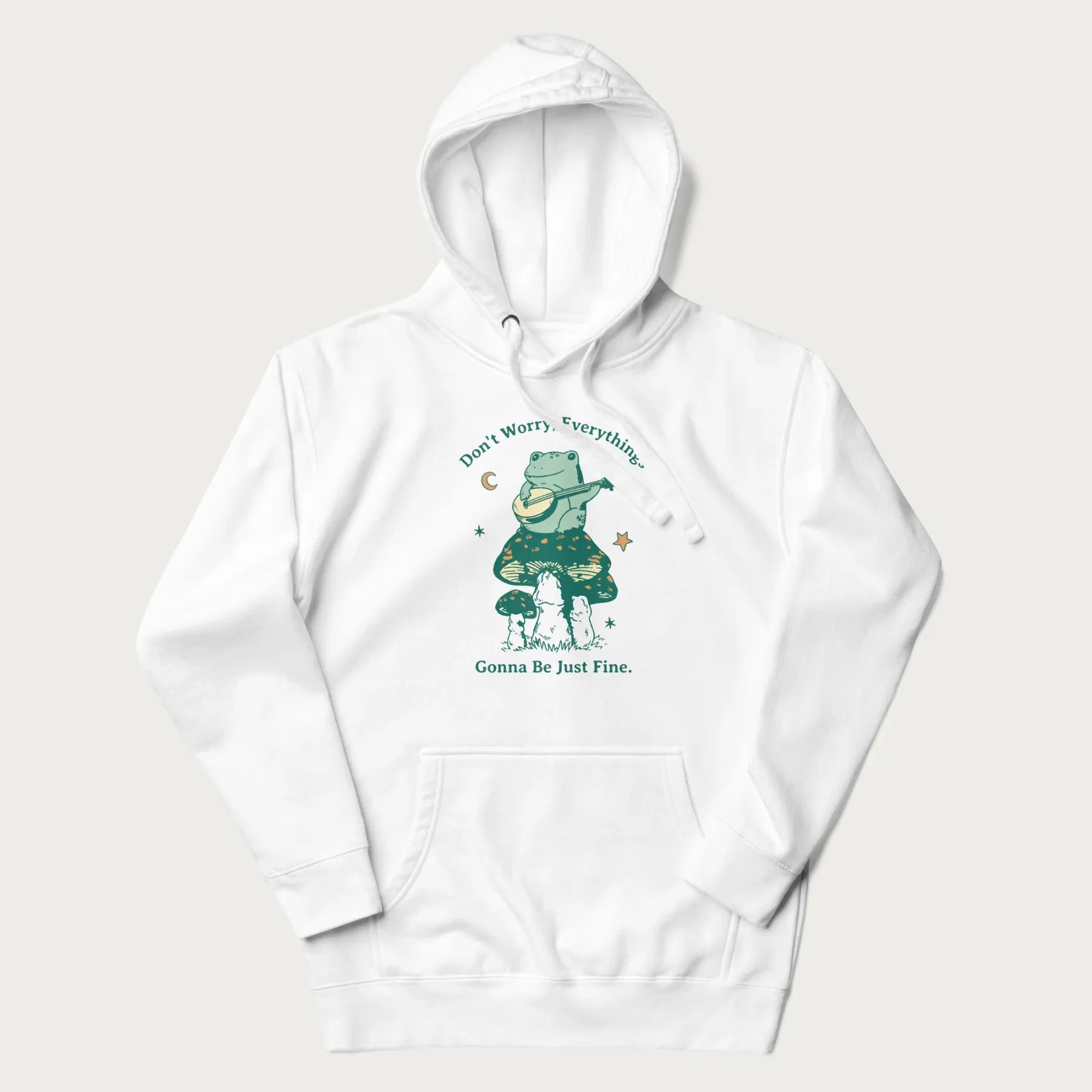 White hoodie with a graphic of a frog playing a banjo on a mushroom under the moon and stars, with the text 'Don't Worry, Everything's Gonna Be Just Fine.'