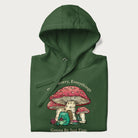 Folded forest green hoodie with a graphic of a frog knitting under a large mushroom with the text 'Don't Worry, Everything's Gonna Be Just Fine'.