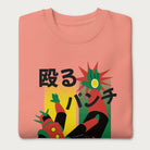 Folded light pink sweatshirt with Japanese text and a retro mecha punch graphic.