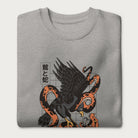 Folded light grey sweatshirt with Japanese text and a graphic of an eagle and a snake in combat.