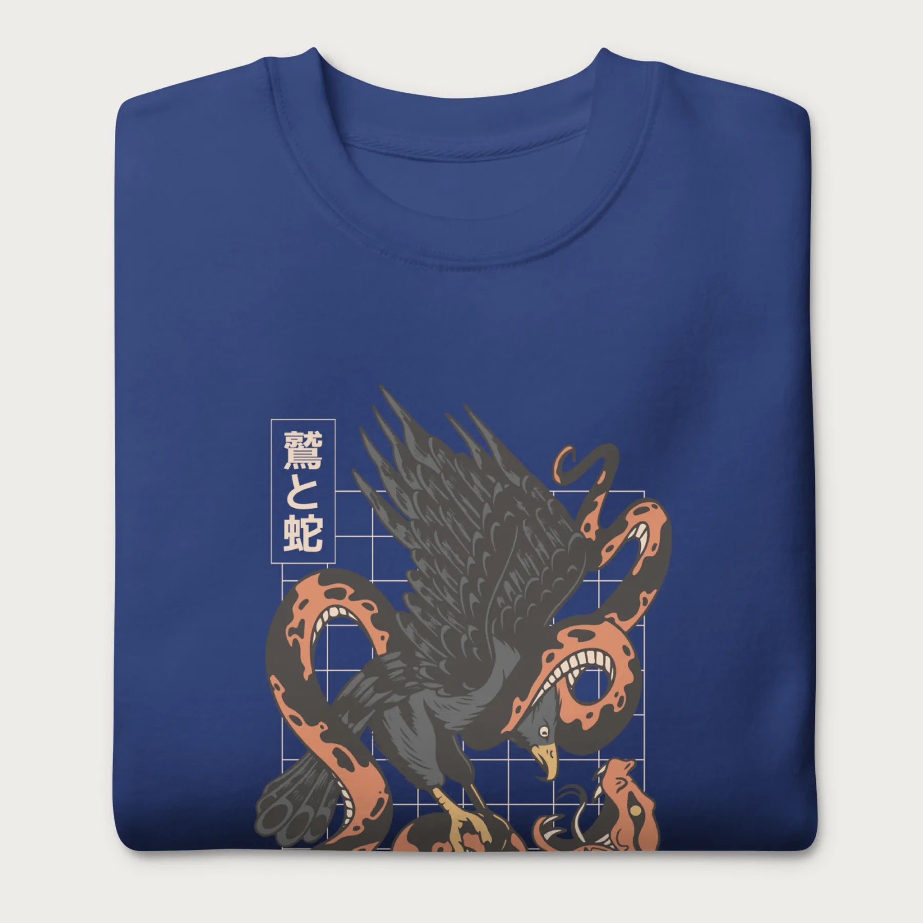 Folded royal blue sweatshirt with Japanese text and a graphic of an eagle and a snake in combat.