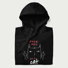 Folded black hoodie with a graphic of a cat raising its middle fingers, with the phrase "F*ck You, I'm a Cat" in red text.