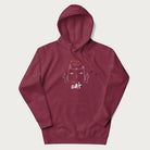 Maroon hoodie with a graphic of a cat raising its middle fingers, with the phrase "F*ck You, I'm a Cat" in red text.