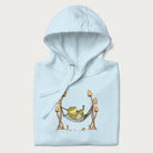 Folded light blue hoodie with a graphic of a frog lounging in a hammock between tall mushrooms.
