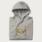 Folded light grey hoodie with a graphic of a frog lounging in a hammock between tall mushrooms.