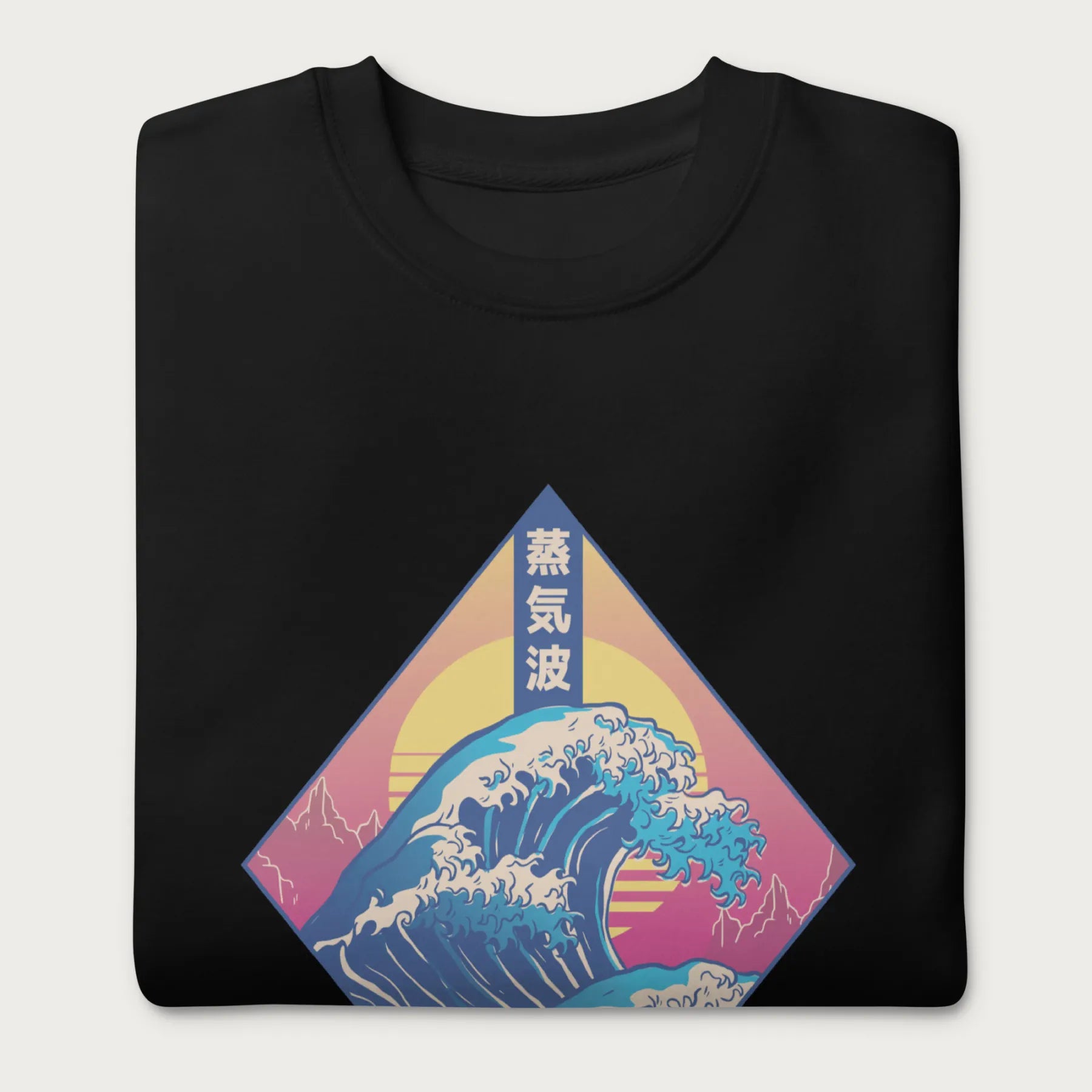 Folded black sweatshirt with a graphic of the Japanese Great Wave, a retro sun, and Japanese text.