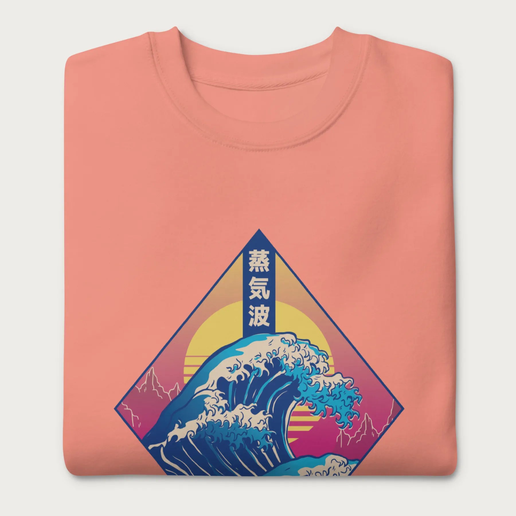 Folded light pink sweatshirt with a graphic of the Japanese Great Wave, a retro sun, and Japanese text.