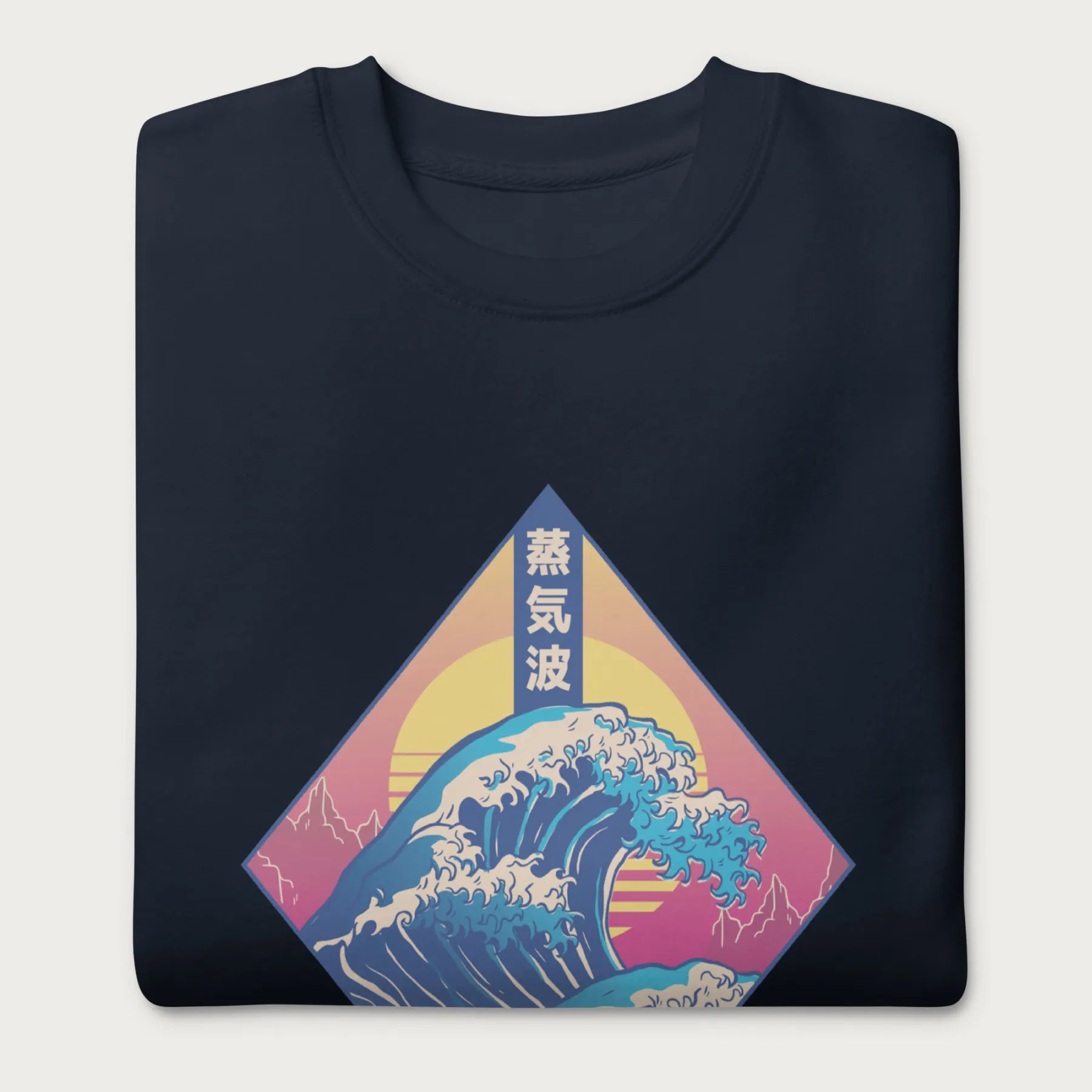 Folded navy blue sweatshirt with a graphic of the Japanese Great Wave, a retro sun, and Japanese text.