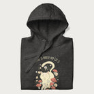 Folded dark grey hoodie with a graphic of a cat nestled among flowers and mushrooms with the text 'Home is Where My Cat Is' above.