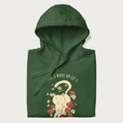 Folded forest green hoodie with a graphic of a cat nestled among flowers and mushrooms with the text 'Home is Where My Cat Is' above.