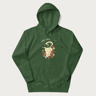 Forest green hoodie with a graphic of a cat nestled among flowers and mushrooms with the text 'Home is Where My Cat Is' above.