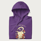 Folded purple hoodie with a graphic of a cat nestled among flowers and mushrooms with the text 'Home is Where My Cat Is' above.