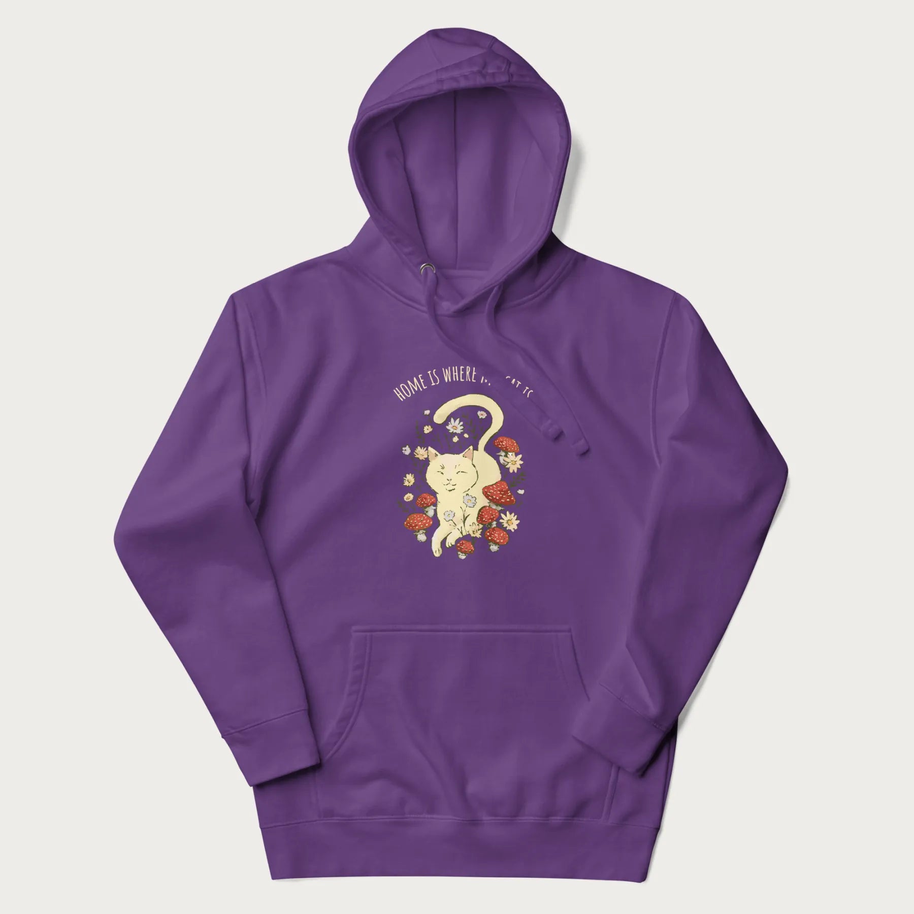 Purple hoodie with a graphic of a cat nestled among flowers and mushrooms with the text 'Home is Where My Cat Is' above.