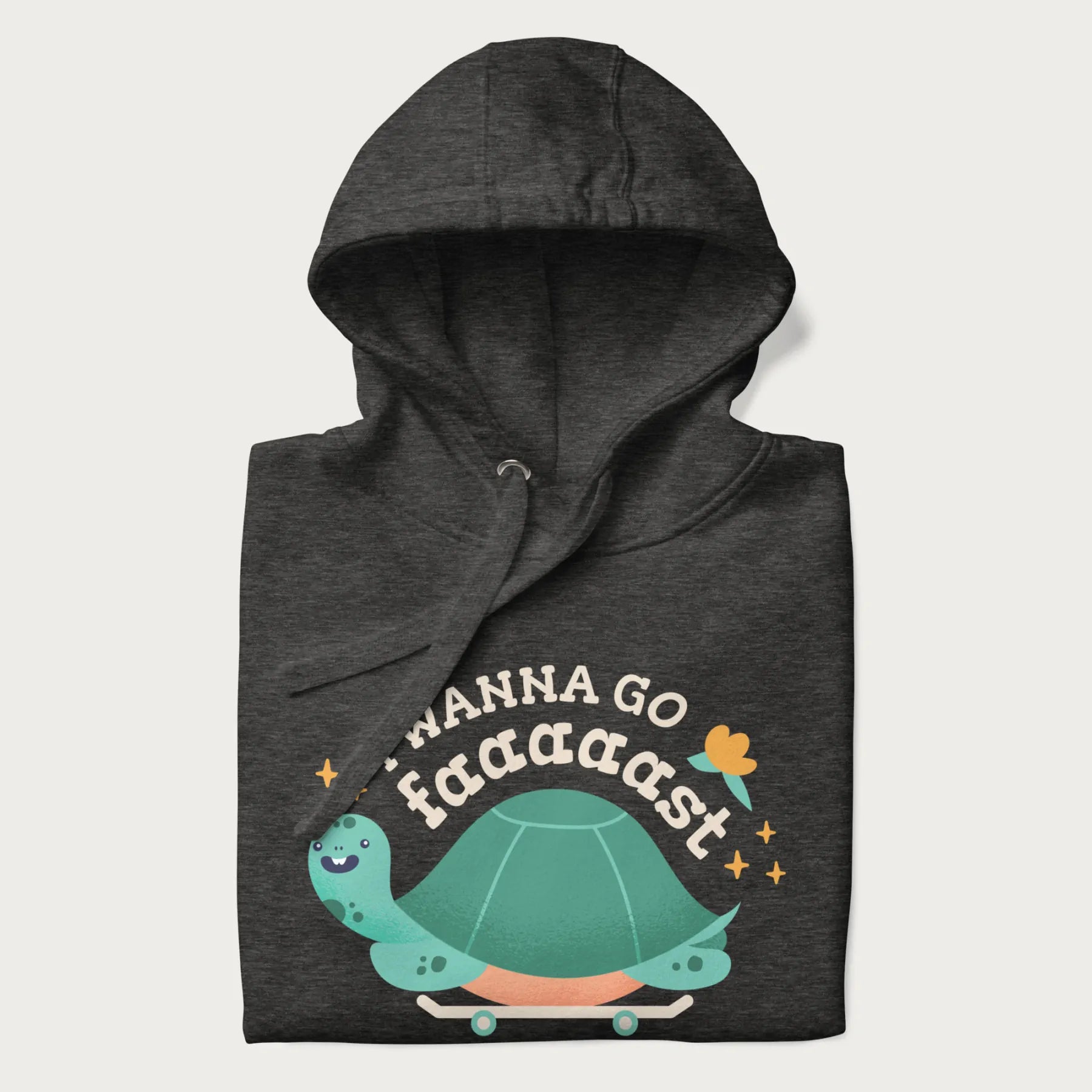 Folded dark grey hoodie with a graphic of a happy turtle on a skateboard and the text 'I Wanna Go Faaaaast'.