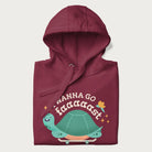 Folded maroon hoodie with a graphic of a happy turtle on a skateboard and the text 'I Wanna Go Faaaaast'.