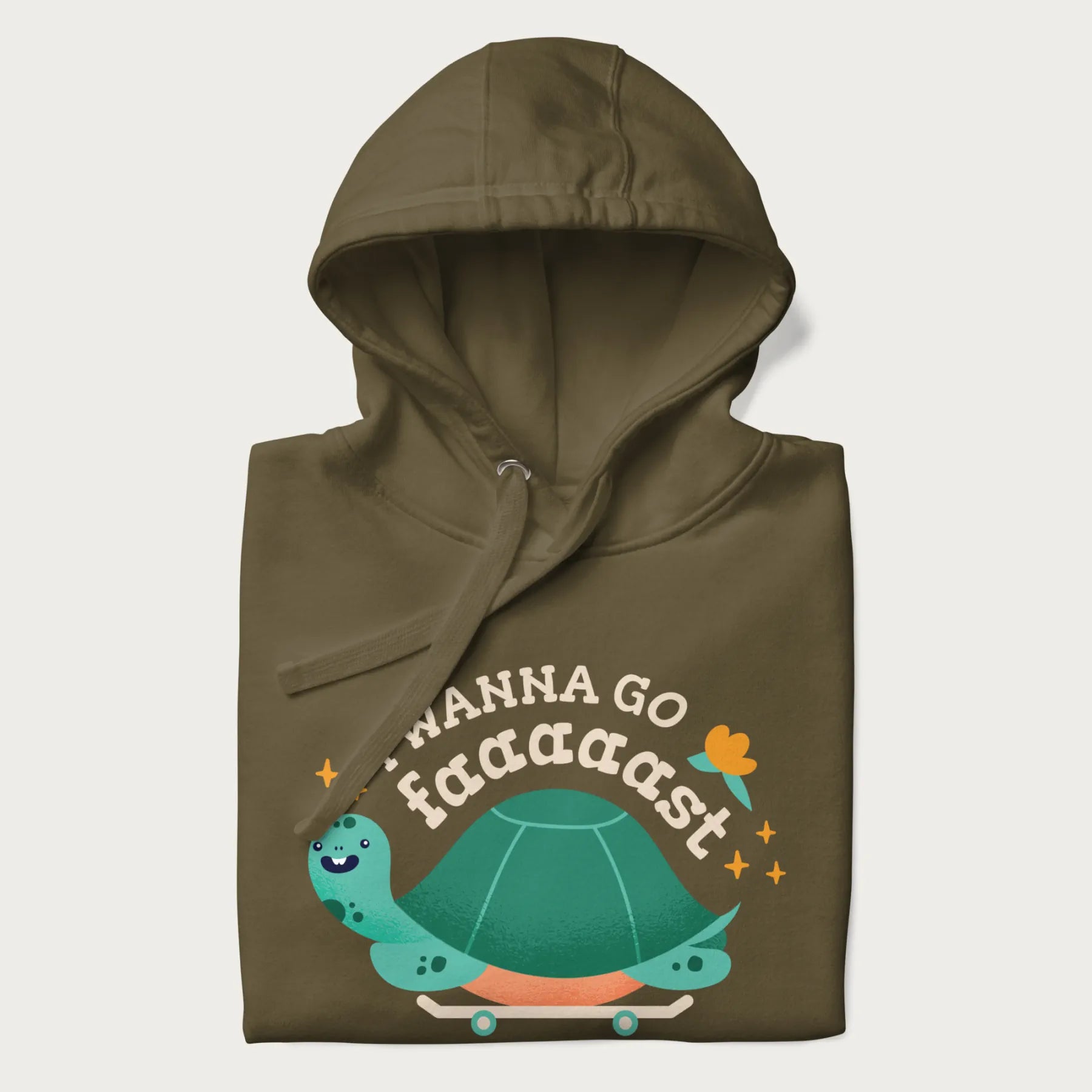 Folded military green hoodie with a graphic of a happy turtle on a skateboard and the text 'I Wanna Go Faaaaast'.
