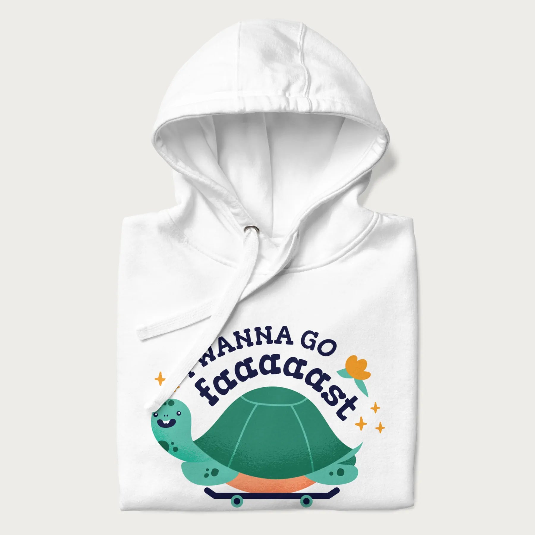 Folded white hoodie with a graphic of a happy turtle on a skateboard and the text 'I Wanna Go Faaaaast'.